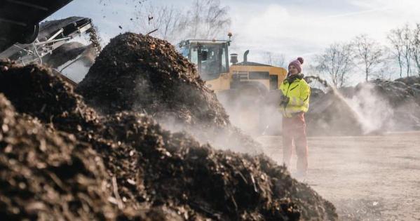 man in front of a giant compost pile