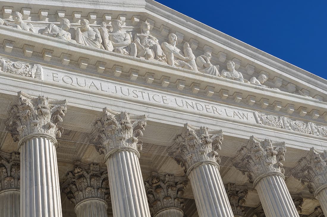 Supreme Court pediment with nine figures, inscription reads 