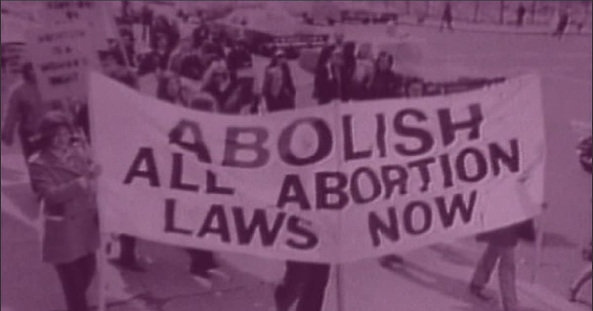 People carrying banner that reads "abolish all abortion laws now"