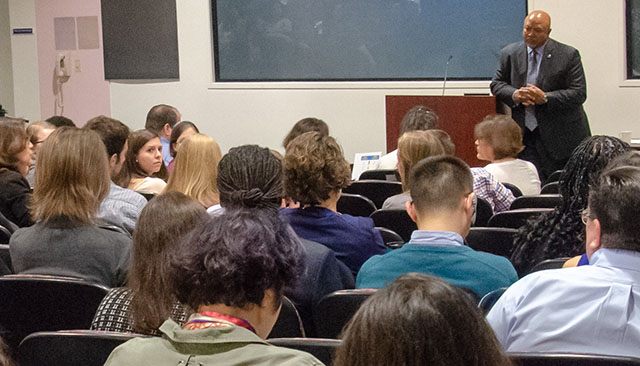 professor lecturing a group of federal workers