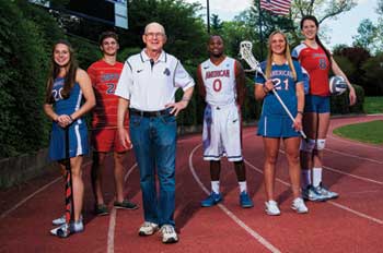 Ted Riggelheim stands in front of several AU student-athletes