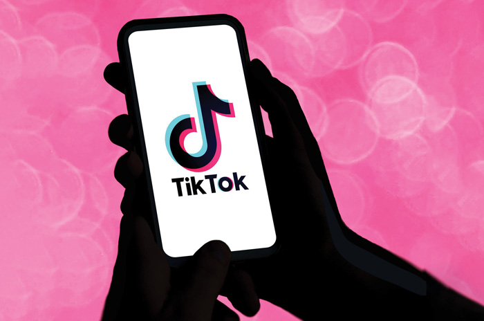 hand holding a phone with TikTok