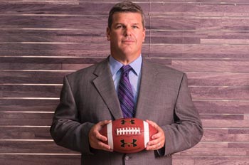 Ryan Kuehl holding a football