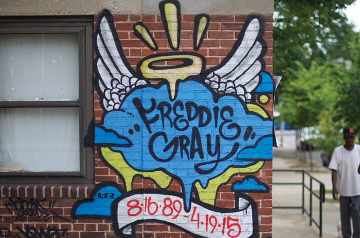 brick wall with graffiti that says "Freddie Gray RIP"