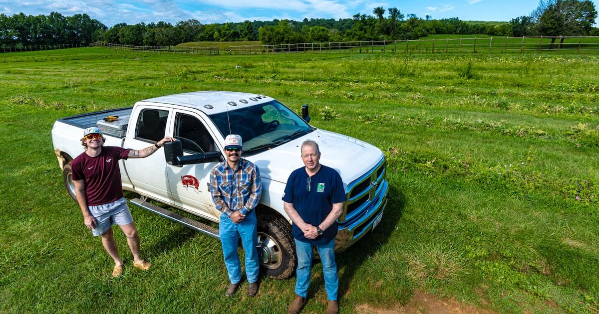 From left, Patrick Atwell, Sean Barrett, and Rick Putnam stand in front of their Ram work truck at Airlie Berkshire Farm. Photo by Jeff Watts. 