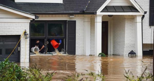 Residents in Georgia use buckets to get water out of their house brought by Hurricane Helene. Photo from Getty. 