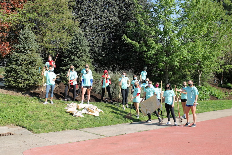 AU Women’s Soccer Team participating in Campus Beautification Day behind Reeves Field