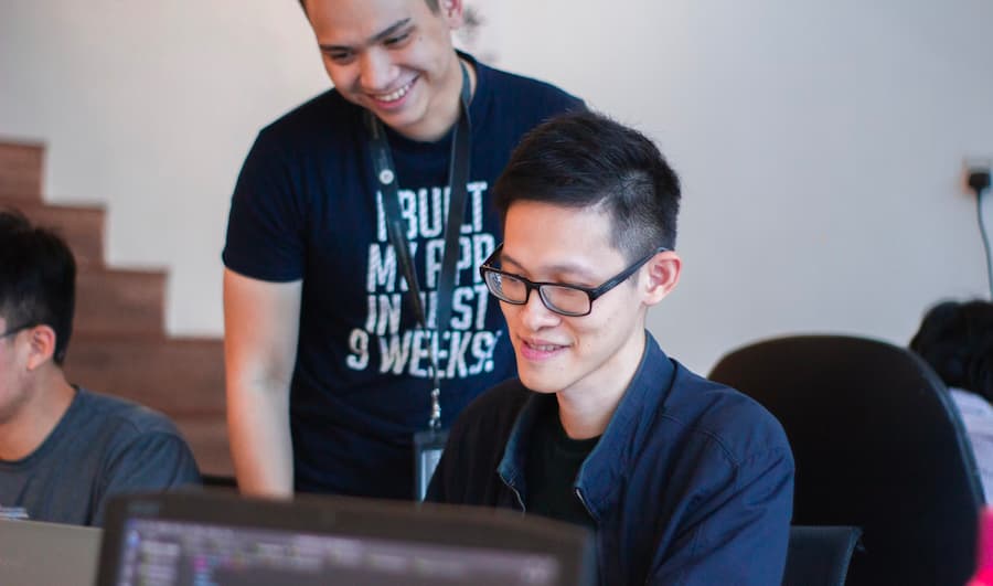 Mentor guiding a coding student. Credit: Next Academy, Unsplash.