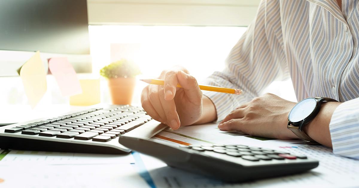 Person in front of a computer keyboard and calculator