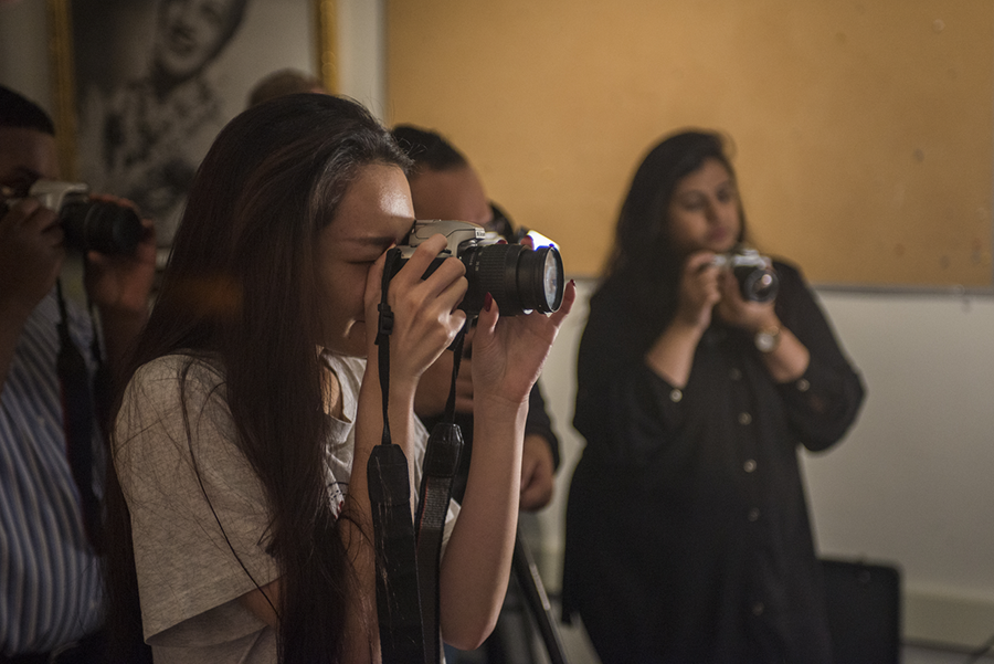 Several students hold cameras