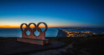 Sculpture of olympic rings above a city