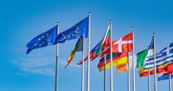 Flags of different European Union member states against a blue background.