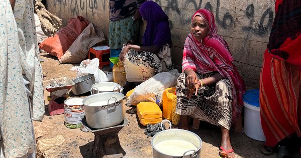 A milk seller in Ethiopia sits near a jug of milk