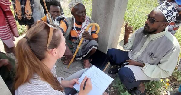 SIS professor Lauren Carruth takes notes while speaking to a camel broker