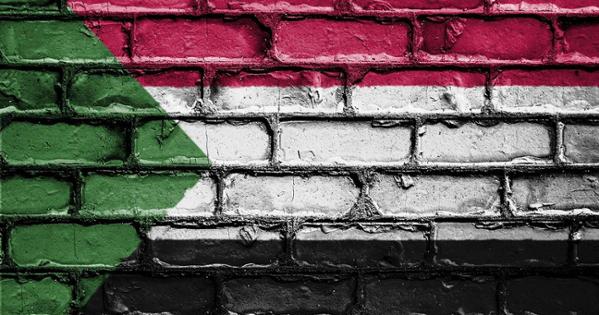 The colors of Sudan's flag is shown on a brick background