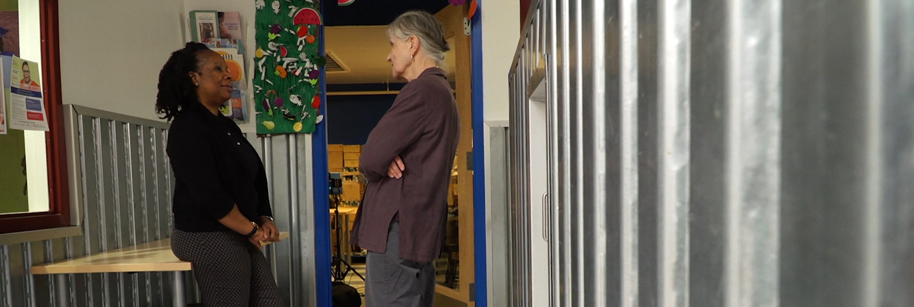 Two women talking in a hallway