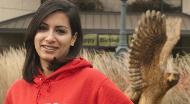 Student with American University hoodie poses on the quad.