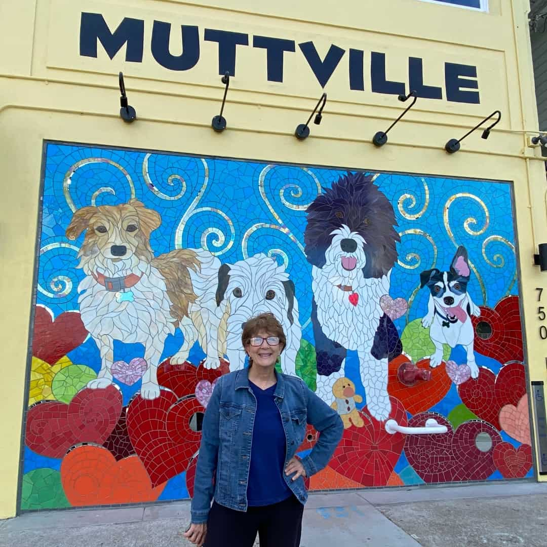 Patty stands in front of the Muttville Mural