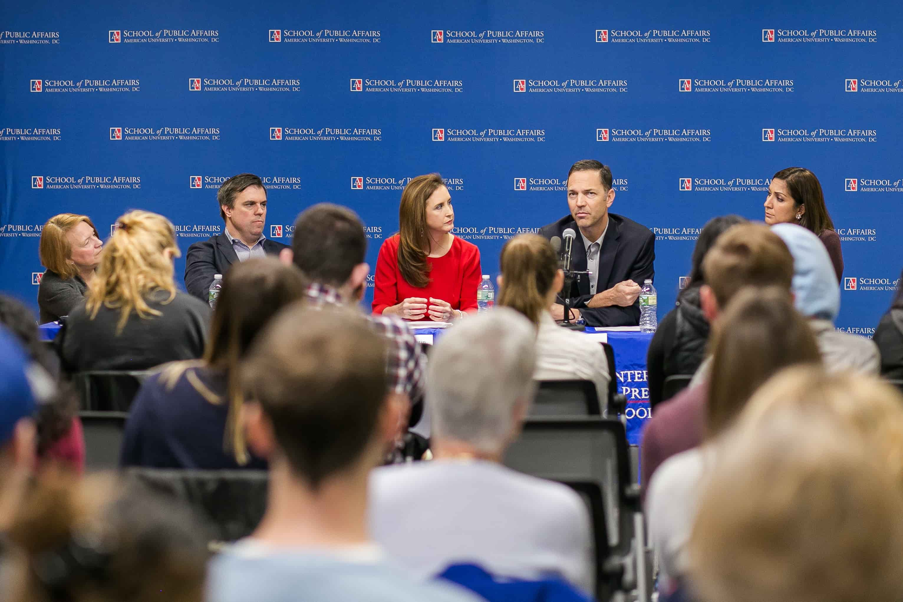 Panelists for midterm election discussion speak to a crowd.