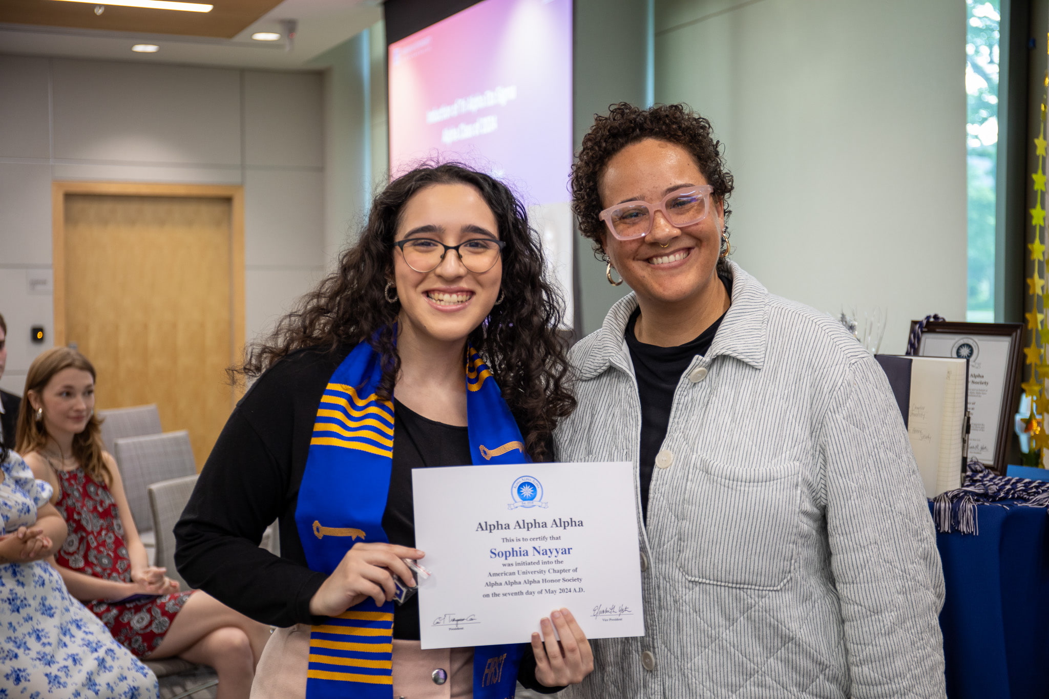 A student who has been inducted into Tri Alpha poses with the Tri Alpha advisor as she holds her Tri Alpha certificate.