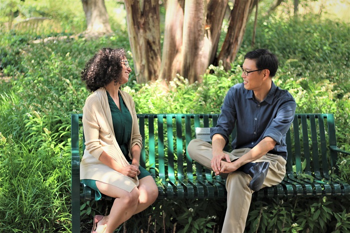 Two students sit on a bench to exchange languages