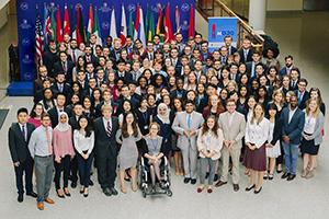 Entire group of students in the SIS atrium after 2017 Model G20. Flags behind students.