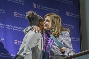 Professor Gemma Puglisi, right, hugs student award winner