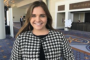 Female student with black and white jacket at a conference. 